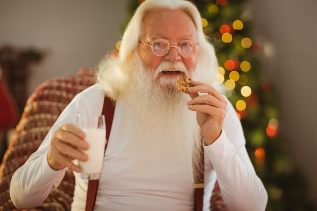 Smiling santa claus eating a cookie