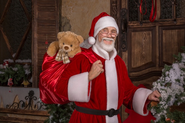 Smiling Santa Claus holding a bag with presents