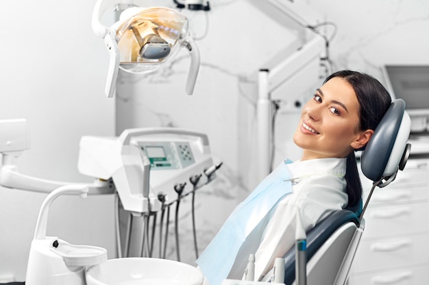 smiling and satisfied patient in a dental office after treatment.