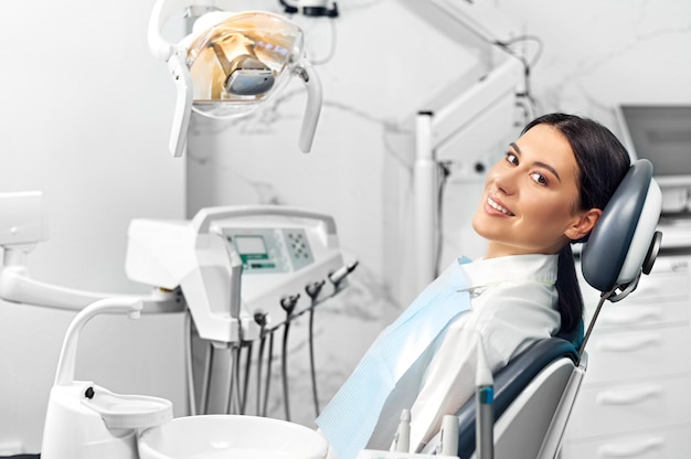 Smiling and satisfied patient in a dental office after treatment.