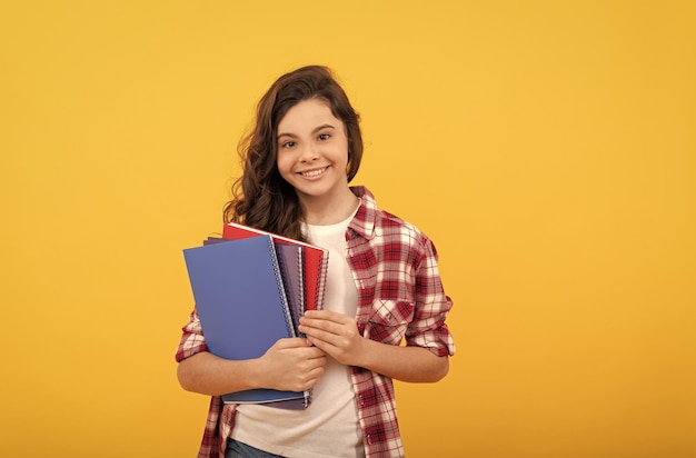 Smiling school child ready to study with copybooks knowledge