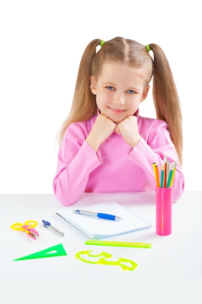 Smiling school girl sitting at table