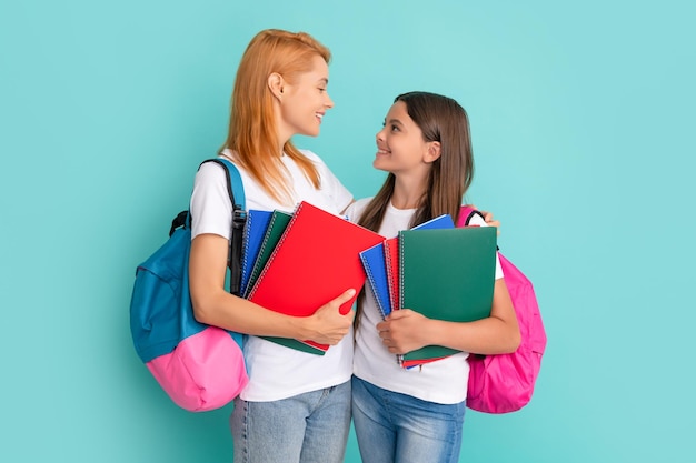 Smiling school pupil and student holding textbooks and backpack\
study