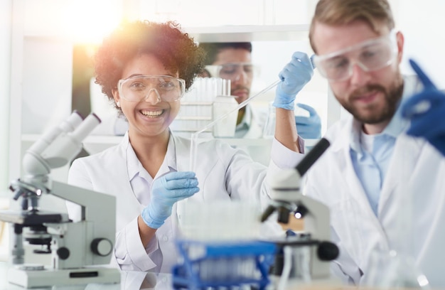 Smiling scientists looking at camera arms crossed in laboratory