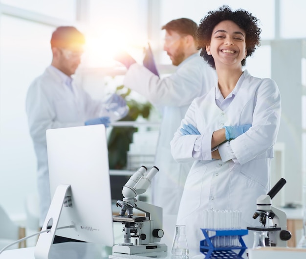 Smiling scientists looking at camera arms crossed in laboratory