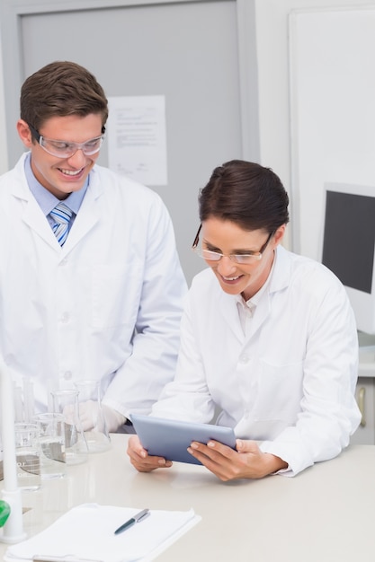 Smiling scientists using tablet 