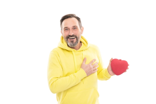 Smiling senior guy hold present isolated on white man in yellow hoody adult valentine hold romantic gift donation concept love symbol valentines day mature happy man with heart shape box