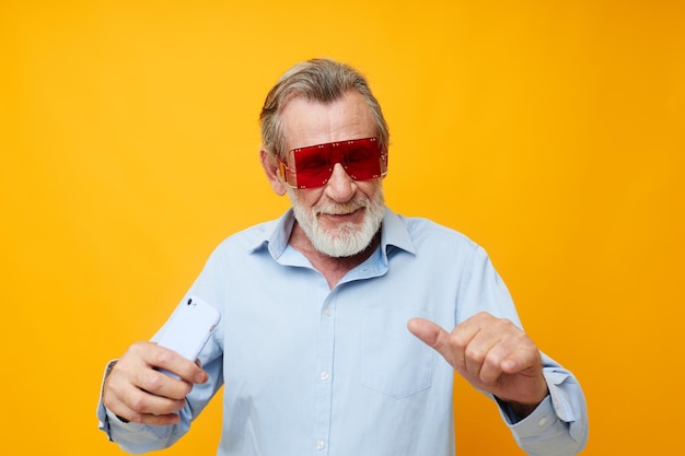 Smiling senior man against yellow background