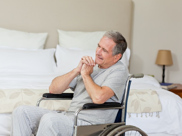 Smiling senior man in his wheelchair  at home