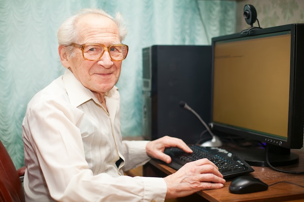 Smiling Senior Man Near Computer