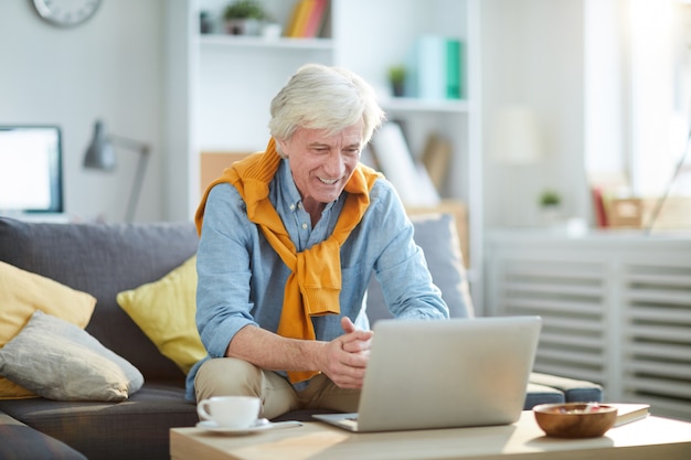 Smiling Senior Man Using Laptop