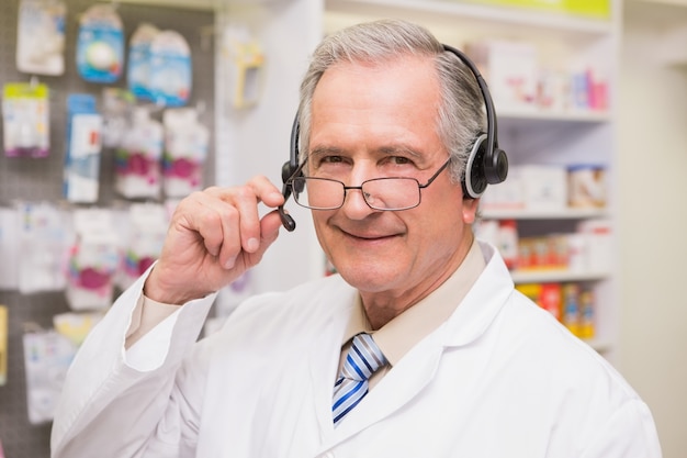 Smiling senior pharmacist with headphone 