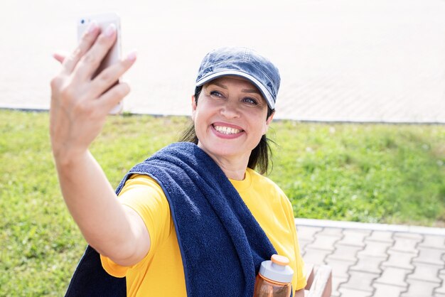 야외 공원에서 selfie 하 고 웃는 수석 sportswoman