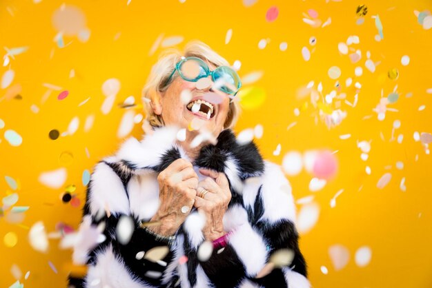 Smiling senior woman against yellow background