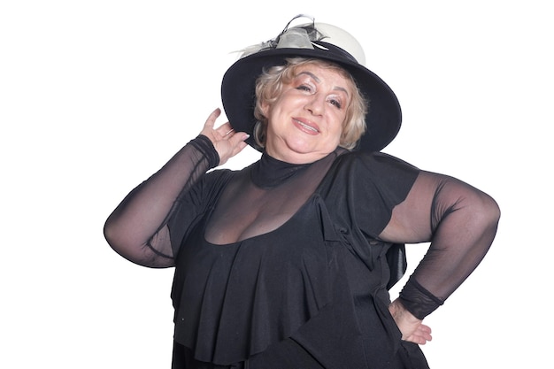 Smiling senior woman in black hat on white background