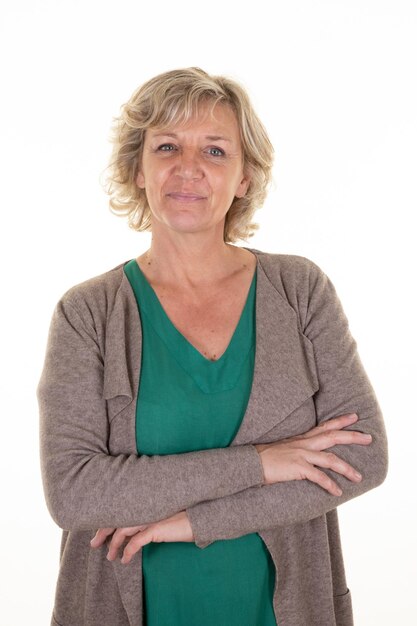 Smiling senior woman blonde happy cheerful mature in green shirt and brown cardigan on white background