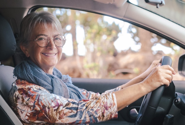 車を運転する笑顔の年配の女性