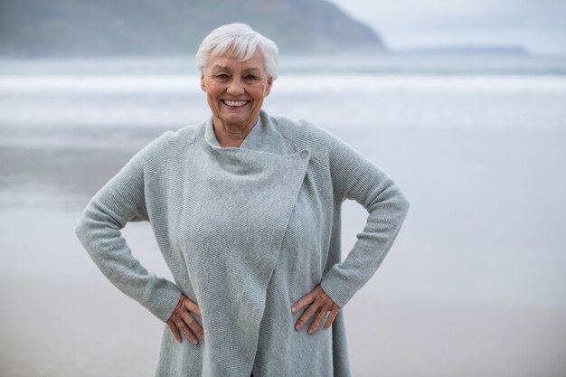 Smiling senior woman standing with hands on hip