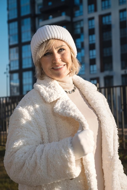 Smiling senior woman wearing winter clothes posing in the city