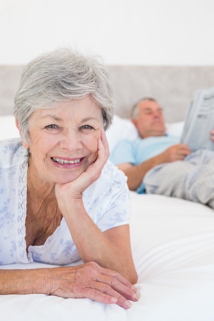 Smiling senior woman with man in bed