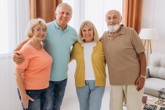 Smiling seniors standing together with a big grin on their faces at care centre