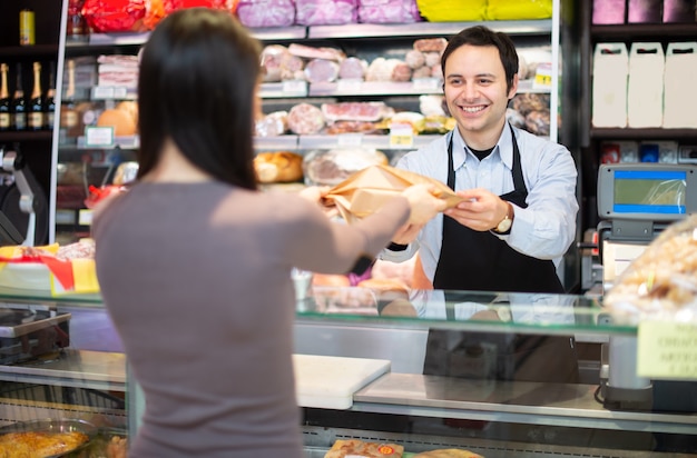 Smiling shopkeeper serving a customer