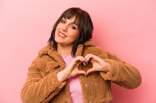 Smiling and showing a heart shape with hands