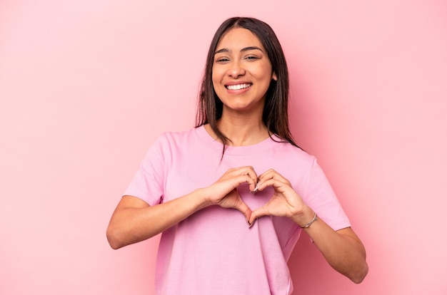 Smiling and showing a heart shape with hands