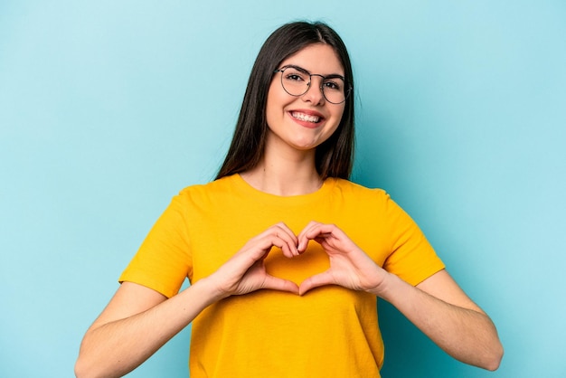 Smiling and showing a heart shape with hands