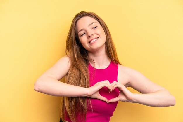 Smiling and showing a heart shape with hands