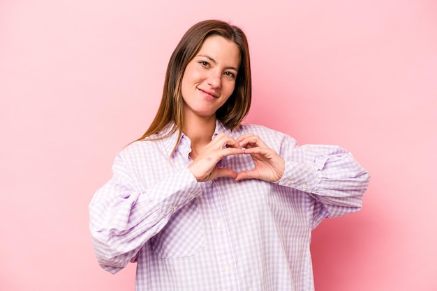 Smiling and showing a heart shape with hands