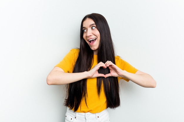 Smiling and showing a heart shape with hands