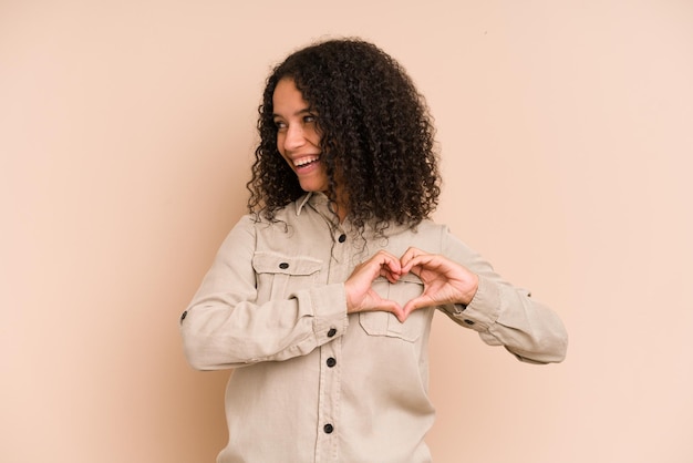 Smiling and showing a heart shape with hands