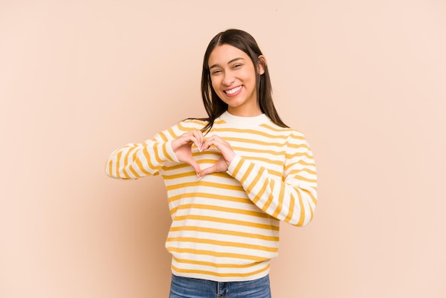 Smiling and showing a heart shape with hands