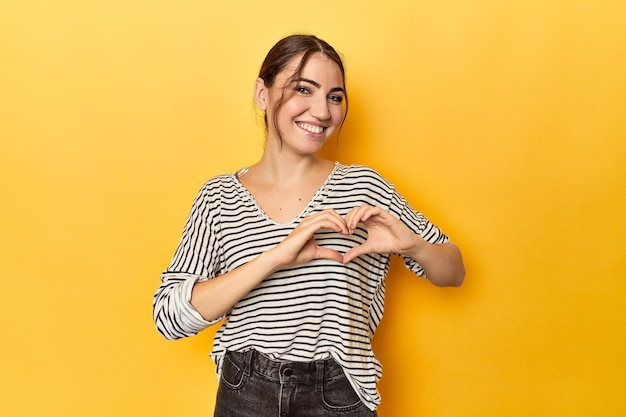 smiling and showing a heart shape with hands