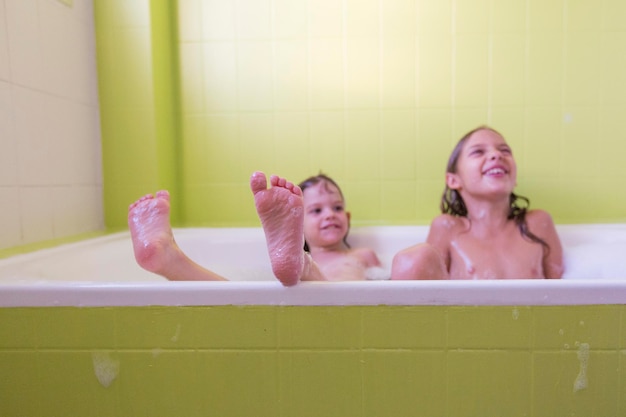 Photo smiling siblings playing in bathtub