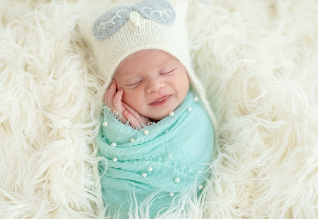 Smiling sleeping newborn kid