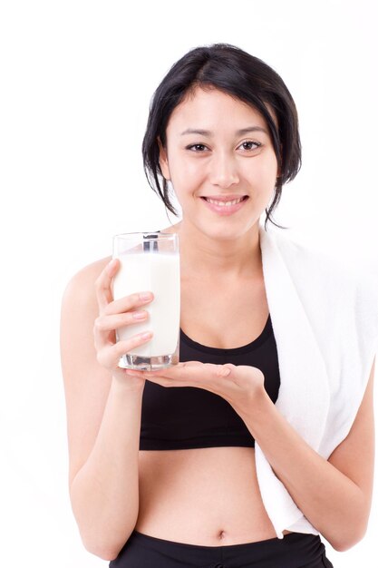 Smiling sporty healthy woman with a glass of milk