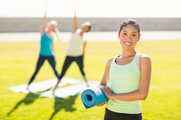 Donna sportiva sorridente davanti agli amici facendo esercizi