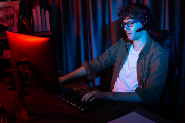Smiling streamer with joystick focusing Esport team on pc with harder Gusher