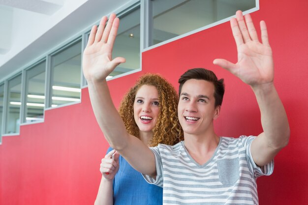 Smiling student gesturing with his friend