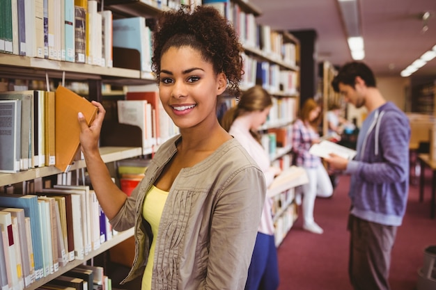 Smiling student picking out a book