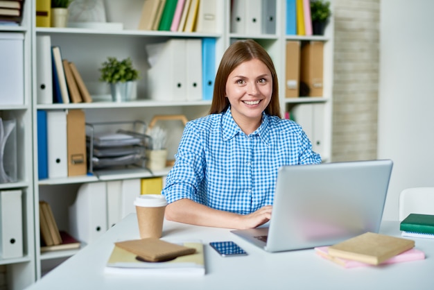 Studente sorridente posing at desk