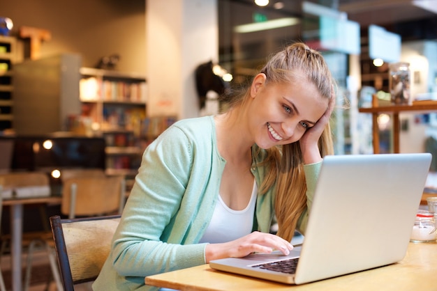 Smiling student using laptop