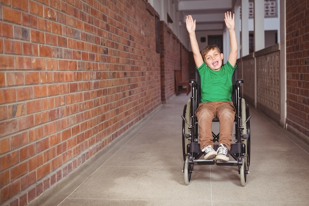 Smiling student in a wheelchair with arms raised