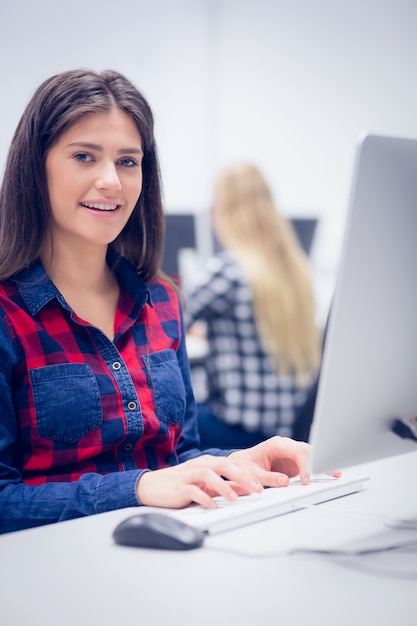 Photo smiling student working on computer at university