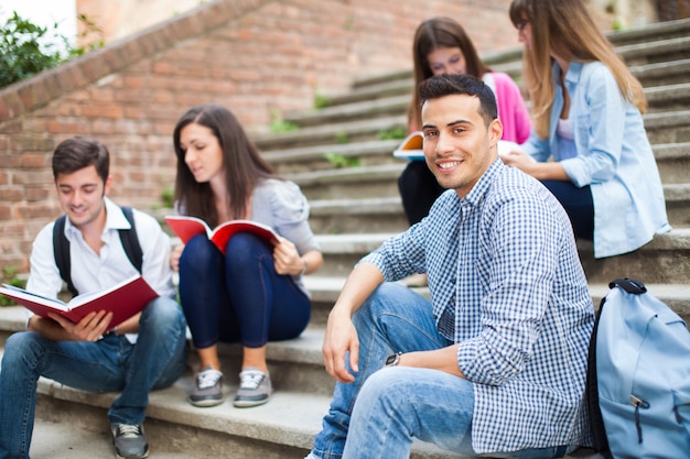 Smiling students sitting on a staircase
