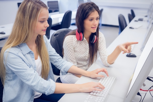 Smiling students using computer at university 