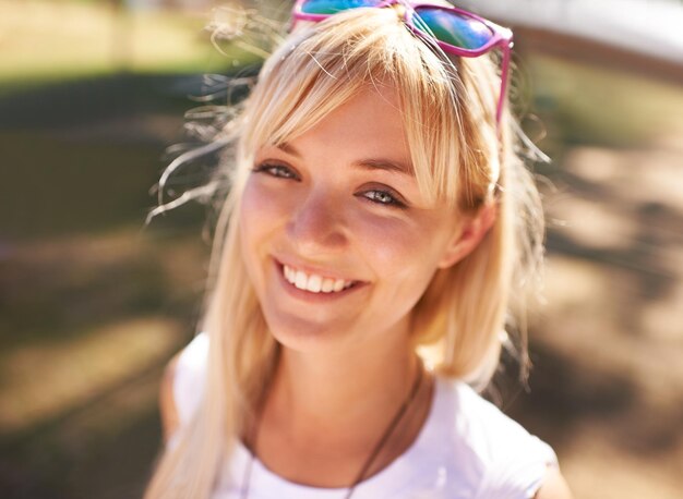 Smiling in the summer sun Portrait of a beautiful young woman enjoying a sunny day outdoors