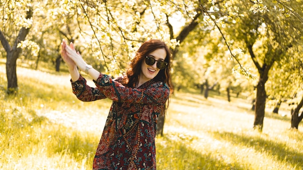 Smiling summer woman with sunglasses. Beautiful Young Woman Outdoor. Enjoy Nature. Healthy Smiling Girl in the Spring Park. Sunny day